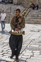 Israel, Jerusalem, East Jerusalem, A Palestinian Arab man with his copper teapot on his back sells a cold drink made of tamarind juice and rose water by the Damascus Gate.