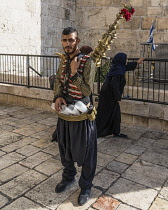 Israel, Jerusalem, East Jerusalem, A Palestinian Arab man with his copper teapot on his back sells a cold drink made of tamarind juice and rose water by the Damascus Gate.