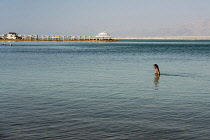 Israel, Ein Bokek, Dead Sea, A young woman wades in the Dead Sea at the resort of Ein Bokek in Israel.