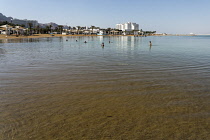 Israel, Ein Bokek, Dead Sea, Visitors relax in the warm waters of the Dead Sea at the resort of Ein Bokek in Israel.