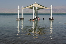 Israel, Ein Bokek, Dead Sea, Visitors relax in the warm waters of the Dead Sea at the resort of Ein Bokek in Israel.