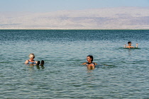 Israel, Ein Bokek, Dead Sea, Visitors relax and float in the warm, bouyant waters of the Dead Sea at the resort of Ein Bokek in Israel.