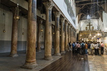 Palestine, Bethlehem, Pilgrims in the nave of the Church of the Nativity in Bethlehem in the Occupied West Bank. The original basilica was built in 339 A.D. over the Nativity Grotto which is the traditional birthplace of Jesus. It is the oldest continuously used place of worship in Christianity. It was destroyed by a fire about 529 A.D. but was rebuilt before 565 A.D. A UNESCO World Heritage Site.