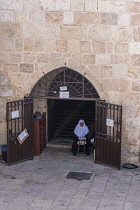 Israel, Jerusalem, A Muslim woman reads at the entrance to the gatehouse of the Eastern Gate or Golden Gate on the Temple Mount or al-Haram ash-Sharif. The Old City of Jerusalem and its Walls is a UNE...