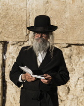 Israel, Jerusalem, Western Wall, A Haredic Jewish man worships at the Western Wall of the Temple Mount in the Jewish Quarter of the Old City. The Old City of Jerusalem and its Walls is a UNESCO World...