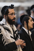 Israel, Jerusalem, Western Wall, An Haredic Jewish man in the traditional tallit - prayer shawl -and tellifin or phylactery chants in worship at the Western Wall of the Temple Mount in the Jewish Quar...