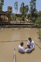 Palestine, Occupied Palestinian Territory, Qasr el Yahud, Christian pilgrims being baptized in the River Jordan at Qasr el Yahud on the Palestine side of the river in the Occupied Territory of the Wes...