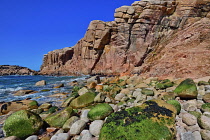 Ireland, County Donegal, Cruit Island, Rocky shoreline with red cliffs and sea.