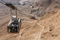 Israel, The cable car up to the ruins of the fortress of Masada in the Judean Desert of Israel. Masada National Park is a UNESCO World Heritage Site. The ruins of a former Roman encampment are visible...