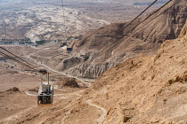 Israel, The cable car up to the ruins of the fortress of Masada in the Judean Desert of Israel. Masada National Park is a UNESCO World Heritage Site. The ruins of a former Roman encampment are visible...