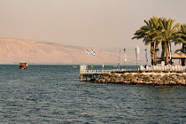 Israel, Tiberius, Sea of Galilee, Boats on the Sea of Galilee and the dock of a shore-side hotel in Tiberius. Across the lake are the Golan Heights, occupied by Israel.