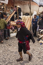 Guatemala, El Quiche Department, Chichicastenango, A cofrade or Catholic religious society leader in his distinctive clothing walks through the market on his way to the Church of Santo Tomas.