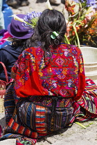 Guatemala, El Quiche Department, Chichicastenango, A woman at the Sunday market  wears the traditional colorful woven huipil or blouse from that town.