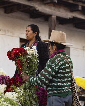 Guatemala, El Quiche Department, Chichicastenango, A Quiche Mayan man buys a bouqet of flowers at the flower market on the steps of the Church of Santo Tomas.