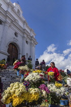 Vendors sell flowers on the steps of the Church of Santo Tomas in Chichicastenango, Guatemala.  The church was built about 1545 on the steps of a Mayan pyramid.