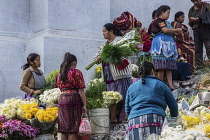 Guatemala, El Quiche Department, Chichicastenango, Quiche Mayan women in traditional dress selling flowers on the steps of the Church of Santo Tomas.