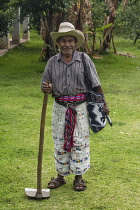 Guatemala, Solola Department, San Pedro la Laguna, A Mayan farmer in traditional dress poses with his hoe.