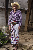 Guatemala, Solola Department, San Pedro la Laguna, 90 year old Mayan man in traditional dress stands in front of his home.
