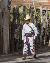 Guatemala, Solola Department, San Pedro la Laguna, An older Mayan man walking along a street in the traditional dress typical.