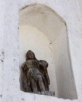 Guatemala, Solola Department, Santa Cruz la Laguna, A very old, weathered religious statue in a niche on the front of the parish church.