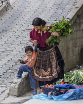 Guatemala, Solola Department, Santa Cruz la Laguna, A Cakchiquel Mayan mother in traditional dress helps her young son.