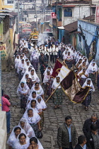 Guatemala, Solola Department, San Pedro la Laguna, Catholic procession of the Virgin of Carmen. Women in traditional Mayan dress with white mantillas over their heads.  Women carry the image of the Vi...
