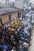 Guatemala, Solola Department, San Pedro la Laguna, Men follow the Catholic procession of the Virgin of Carmen. Women in traditional Mayan dress with white mantillas over their heads.  Women carry the...