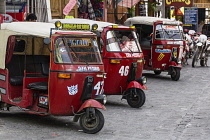 Guatemala, Solola Department, San Pedro la Laguna, A line of mototaxis wait for passengers by the boat dock. Mototaxis or tuk tuks from India are a very economical form of public transportation in muc...