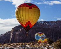 USA, Arizona, Monument Valley, Hot air balloons in the Monument Valley Balloon Festival in the Navajo Tribal Park.  Rain God Mesa is in the background.