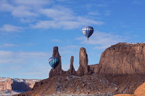 USA, Arizona, Monument Valley, Two hot air balloons fly in front of the Three Sisters in the Monument Valley Balloon Festival in  Navajo Tribal Park.