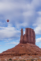 USA, Arizona, Monument Valley, A hot air balloon flying over the West Mitten during the Balloon Festival in the Navajo Tribal Park in Arizona.