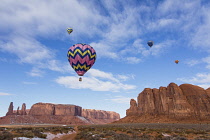 USA, Arizona, Monumnet Valley, Hot air balloons during Balloon Festival fly over Camel Butte in the  Navajo Tribal Park.  The Three Sisters are at left.