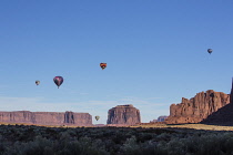 USA, Arizona, Monument Valley, Five hot air balloons fly over the West Mitten, Merrick Butte and Spearhead Mesa during Valley Balloon Festival in the  Navajo Tribal Park.