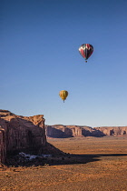 USA, Arizona, Monument Valley, Two hot air balloons fly  during Valley Balloon Festival in the  Navajo Tribal Park.