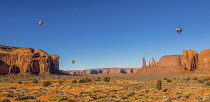USA, Arizona, Monument Valley, Three hot air balloons during  Balloon Festival in the  Navajo Tribal Park.  The Three Sisters are at right.