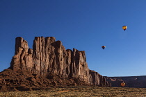 USA, Arizona, Monument Valley, Three hot air balloons fly beside Camel Butte during Balloon Festival in the  Navajo Tribal Park.