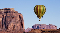 USA, Arizona, Monument Valley, Hot air balloon flying by Merrick Butte during Balloon Festival in the  Navajo Tribal Park.