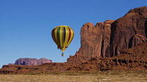 USA, Arizona, Monument Valley, A hot air balloon flying by Spearhead Mesa during Balloon Festival in the Navajo Tribal Park.