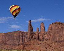 USA, Arizona, Monument Valley, A hot air balloon flying by the Three Sisters during Balloon Festival in the Navajo Tribal Park.