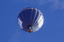 USA, Arizona, Monument Valley, Telephoto view of a hot air balloon firing up its gas flame to gain altitude at a balloon festival in the Navajo Tribal Park.