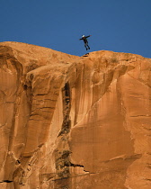 USA, Utah, Moab, A basejumper leaps off the top of the 400 foot vertical face of the Tombstone in Kane Springs Canyon.
