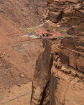 USA, Utah, Moab, Base jumpers prepare to jump from the Mothership Spacenet suspended from the cliffs 950 vertical feet above the valley floor at Mineral Canyon.