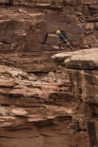 USA, Utah, Moab, A base Jumper jumps off the clifftop 950 feet above the floor of Mineral Canyon.