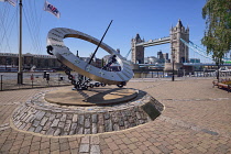 England, London, St Katherineâs Dock , View of Tower Bridge with the Timepiece sculpture resembling a sundial created by Wendy Taylor in 1973.