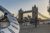 England, London, St Katherine's Dock , View of Tower Bridge at sunset with a section of the Timepiece sculpture resembling a sundial created by Wendy Taylor in 1973.