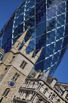 England, London, The Swiss Re building 30 St Mary Axe, alternatively known as the Gherkin, commercial skyscraper designed by architect Sir Norman Foster and opened in April 2004 with St Andrew Undersh...