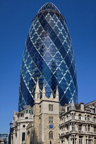 England, London, The Swiss Re building 30 St Mary Axe, alternatively known as the Gherkin, commercial skyscraper designed by architect Sir Norman Foster and opened in April 2004 with St Andrew Undersh...