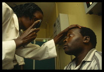 Uganda,Jinja, Eye examination in Jinja Hospital.  Female doctor and male patient.