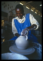 Malawi, , Dedza, Pottery producing fair trade goods for export, potter working at wheel.