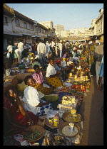 Uganda, Kampala, Busy market scene with row of vendors selling various goods.